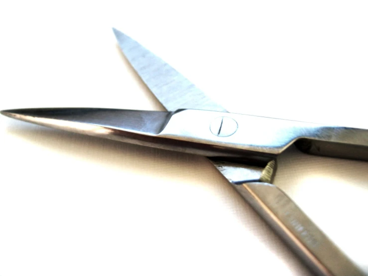 a pair of silver colored scissors against a white background