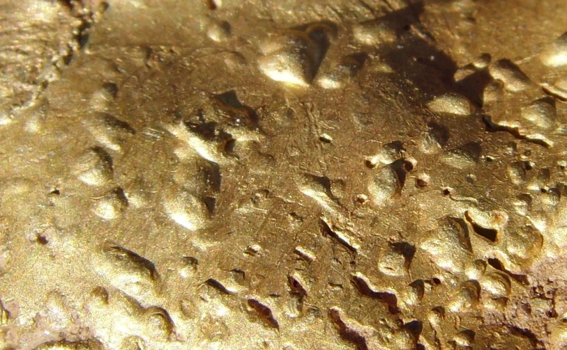 water droplets sitting on a metal plate with gold paint
