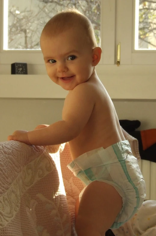 a baby in a diaper and a pillow