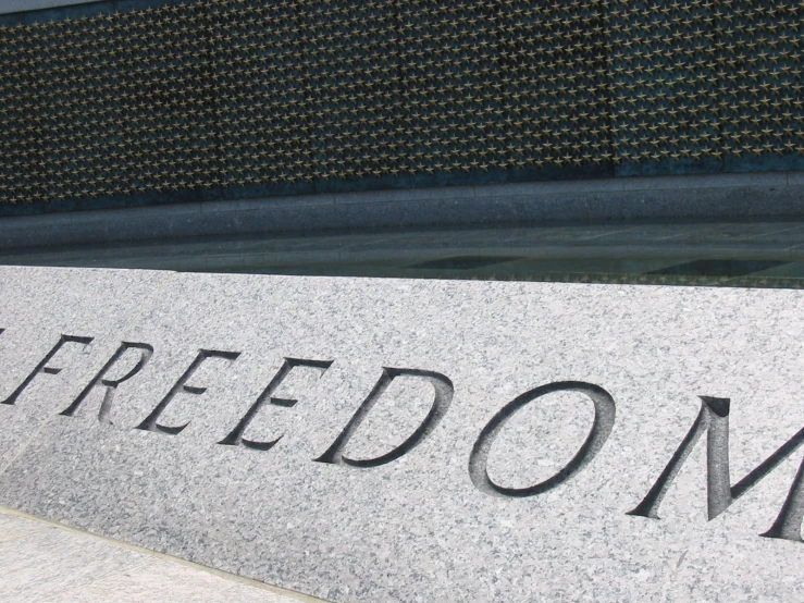a gray stone inscription that says freedom in german
