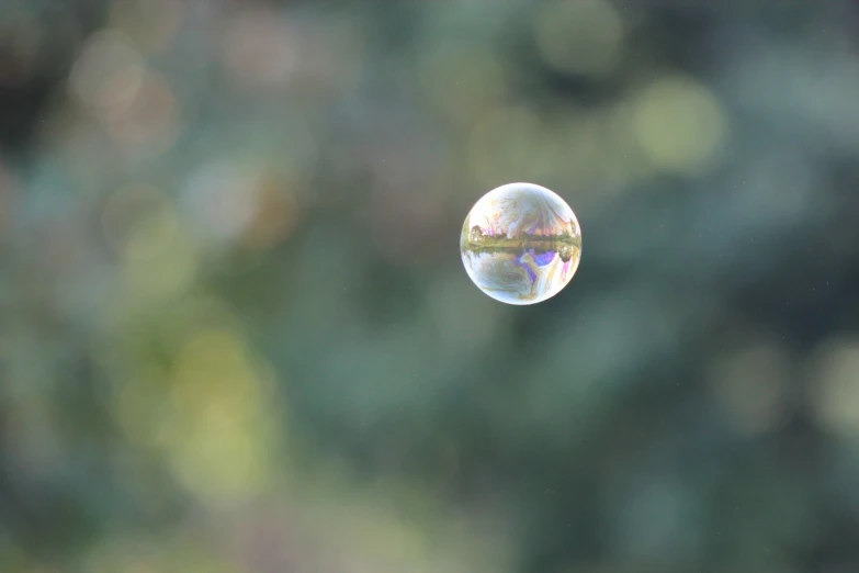 a soap bubble hanging from the top of a pole