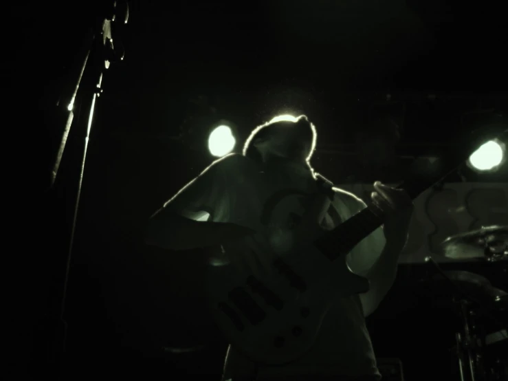 a person that is playing the guitar in the dark