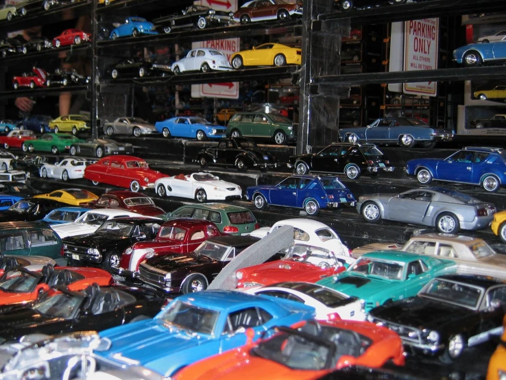 various model cars are stacked on display in a building