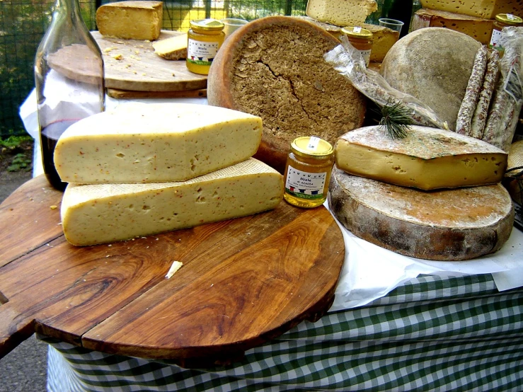 a display table with several cheeses and breads