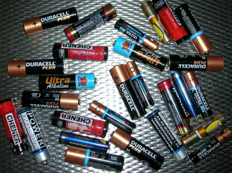 many small batteries are sitting on a metal surface