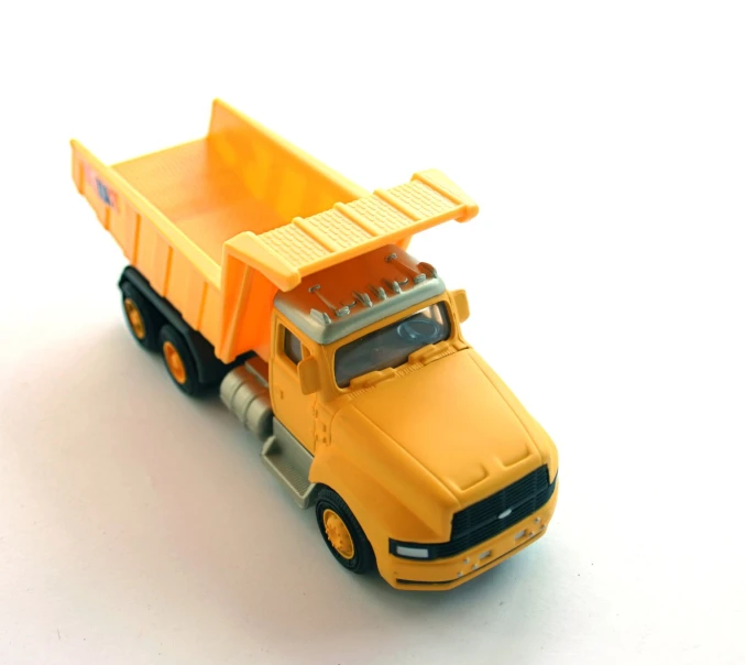 a yellow toy dump truck on a white surface