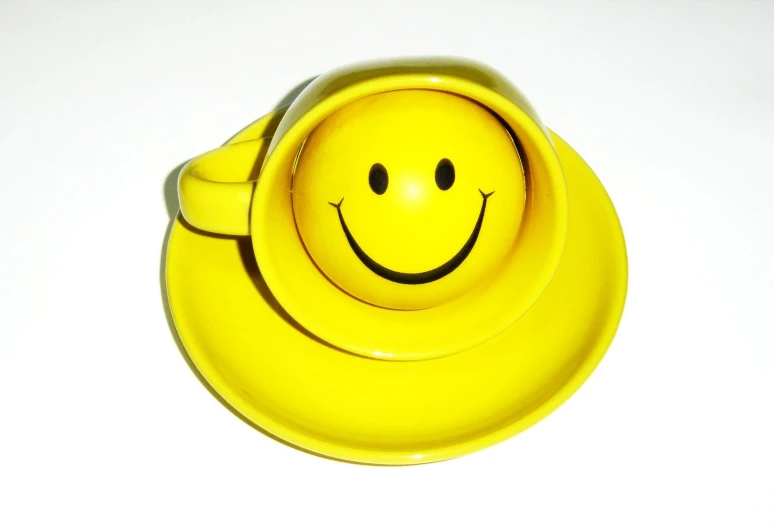 yellow smiley face container with hair clip, sitting on white surface