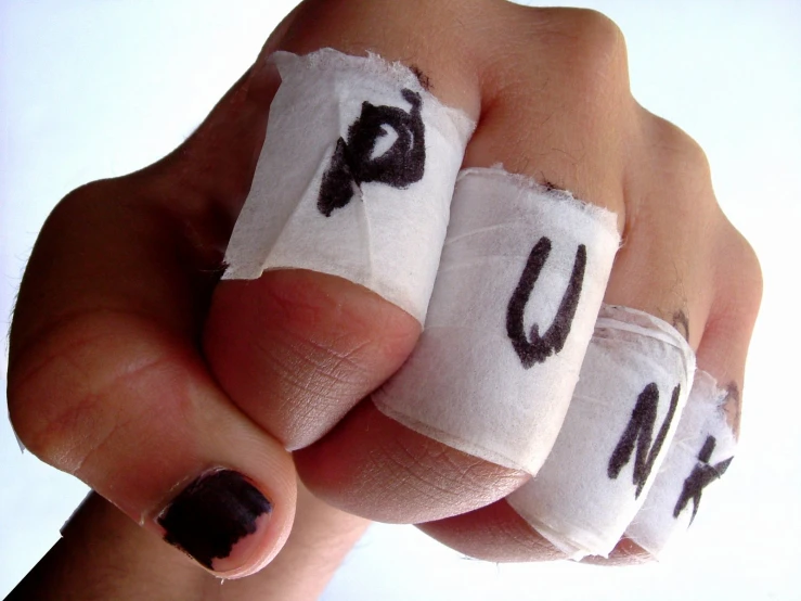 a hand wearing bandages has letters that read u