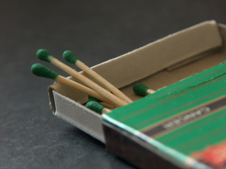 matches in a cardboard box with four green matches