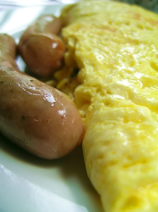 an omelet with sausage is on a white plate