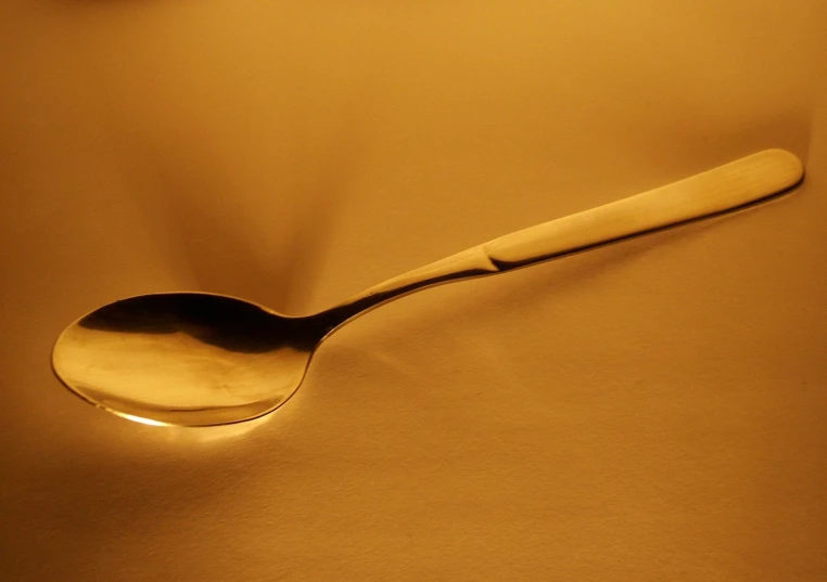a spoon with a glowing face sits on a table