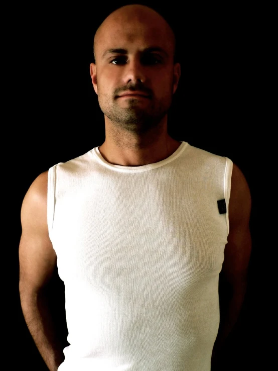 man in a tank top standing with his hands on his hips