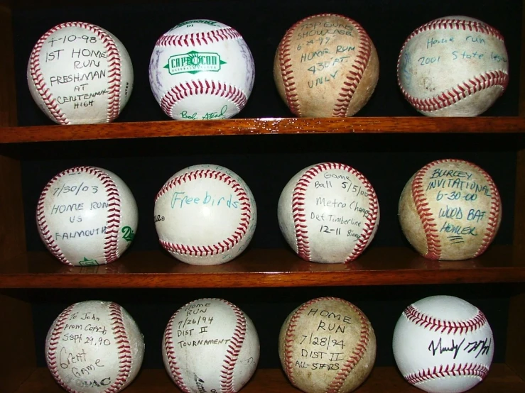 twelve signed baseballs displayed on shelves at a sports store