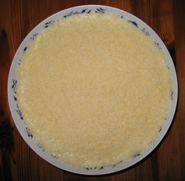 a white bowl with food on a wooden table