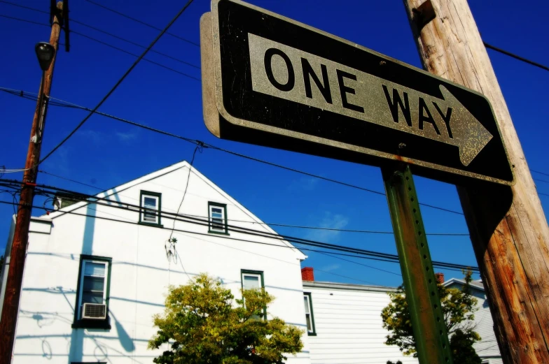 there is a one way street sign in front of a white building