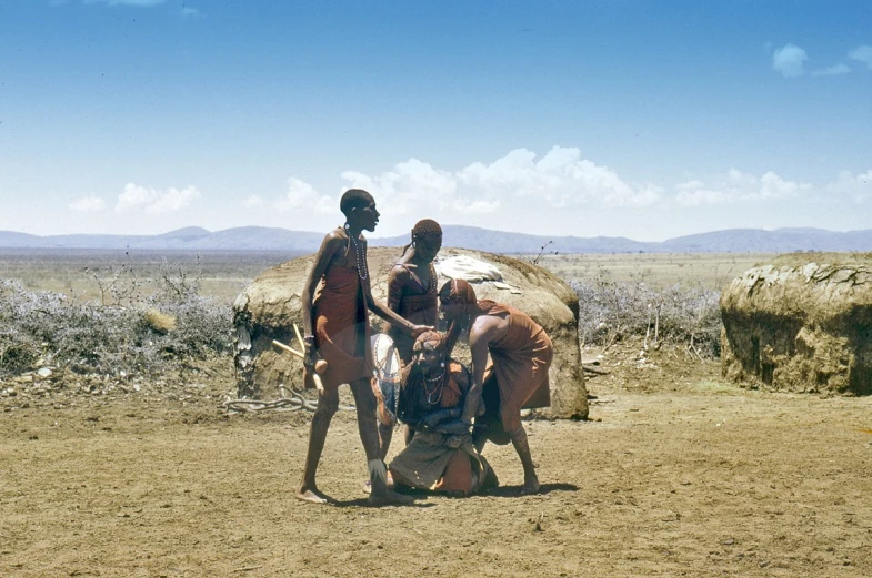 three children are standing by some rocks and a horse