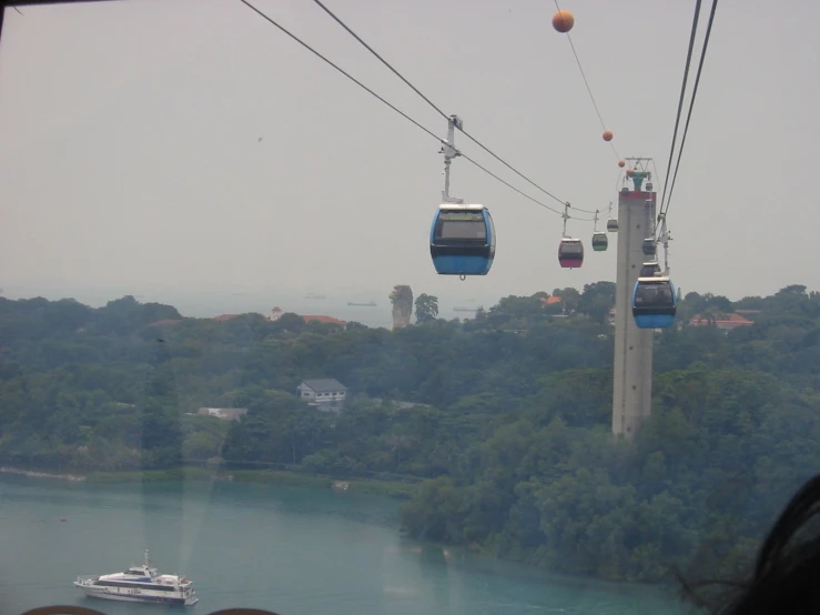 a view from an incline of a large body of water and ski lifts