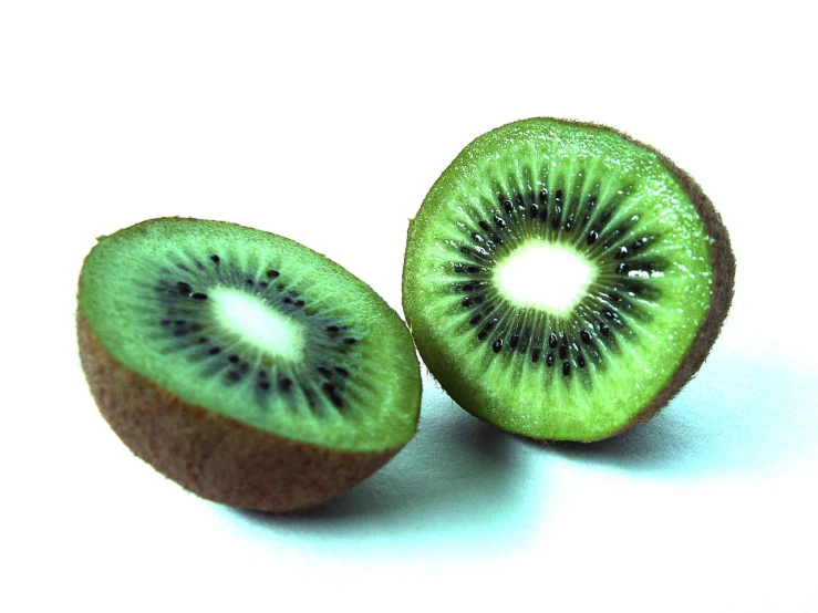 a kiwi cut in half sitting on top of a white surface