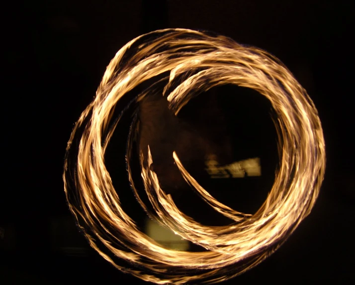 fire spinning in the night time with small orange rings