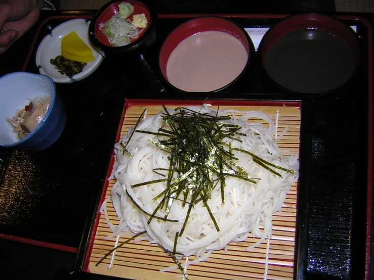 an asian dish with rice and herbs on the side