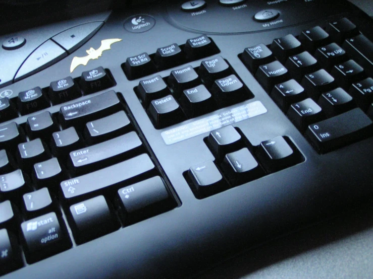 a close up of a batman keyboard sitting on a desk