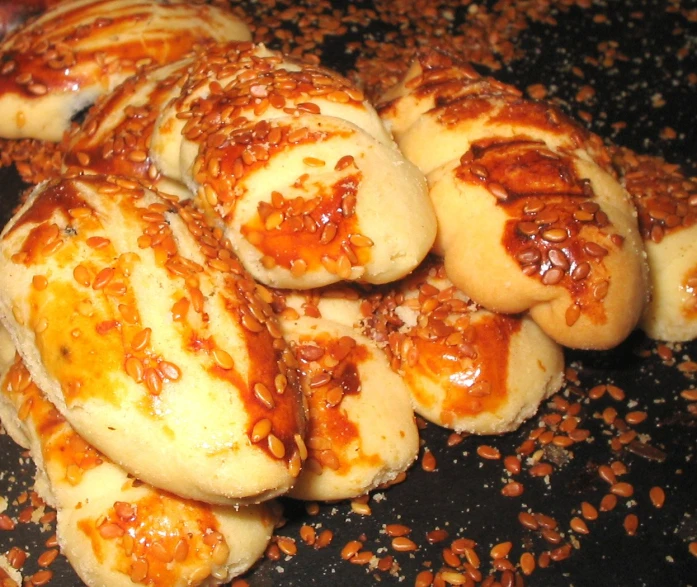 several buns are on a plate covered with sesame seeds