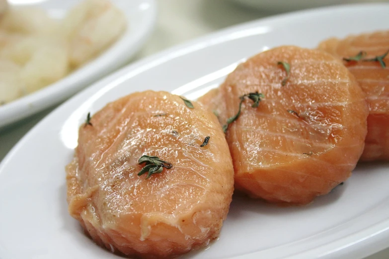 the slices of salmon are on the white plate