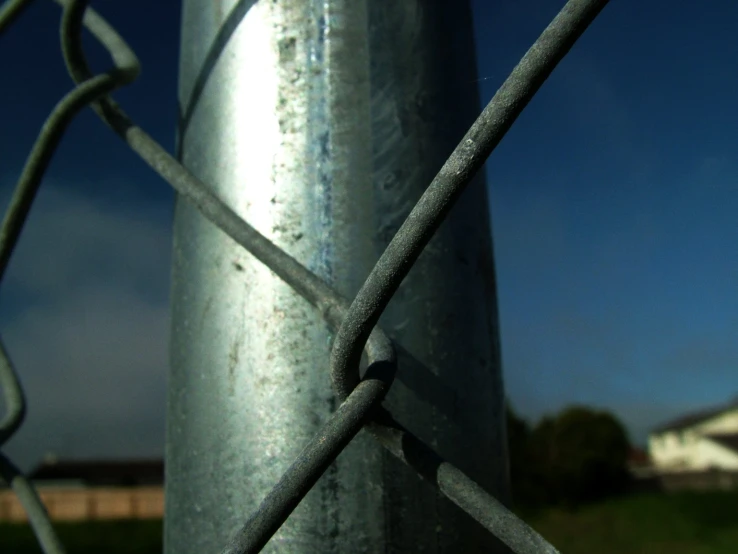 a metal pole with a chain link fence around it