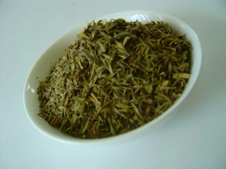 there is dried herbs in a white bowl