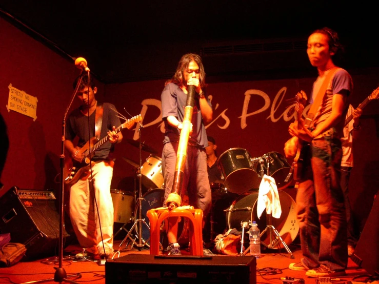 several musicians standing on a stage with guitars