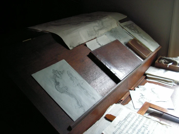 a desk covered with many papers and a book case