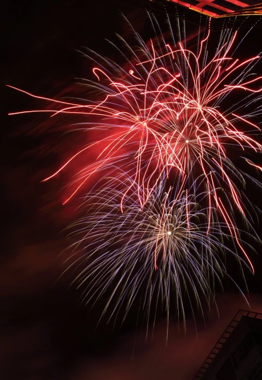 a fireworks display with a building in the background