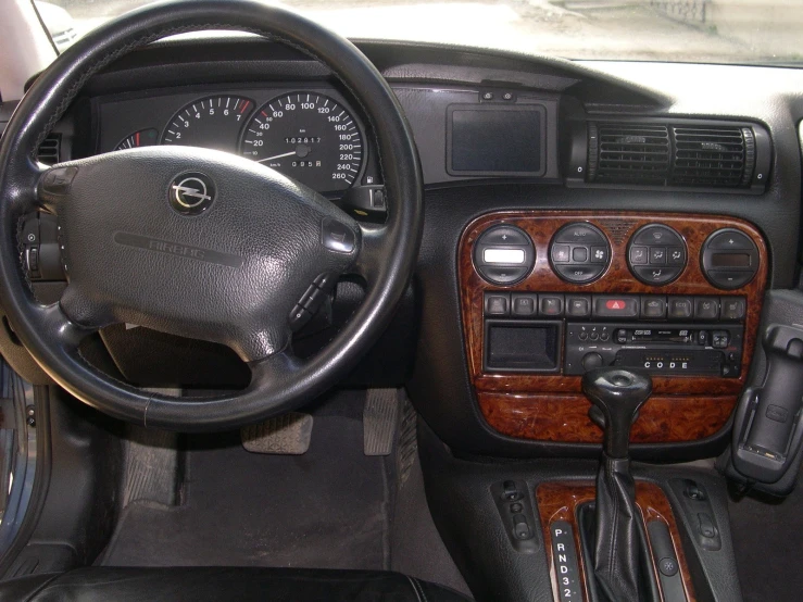 the interior of a car with wood grain, steering wheel controls and dashboard