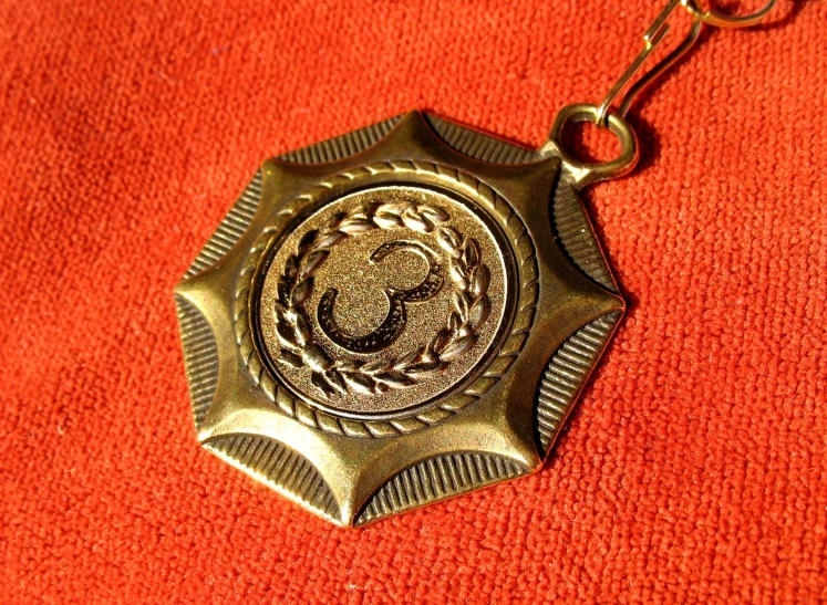 a gold keychain with the shape of a lion is on a red background