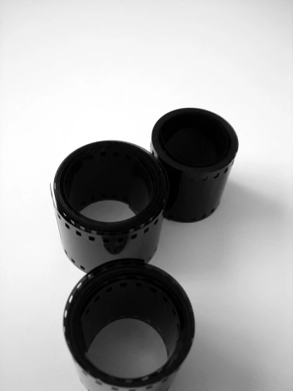 three black cup sitting on top of a white table