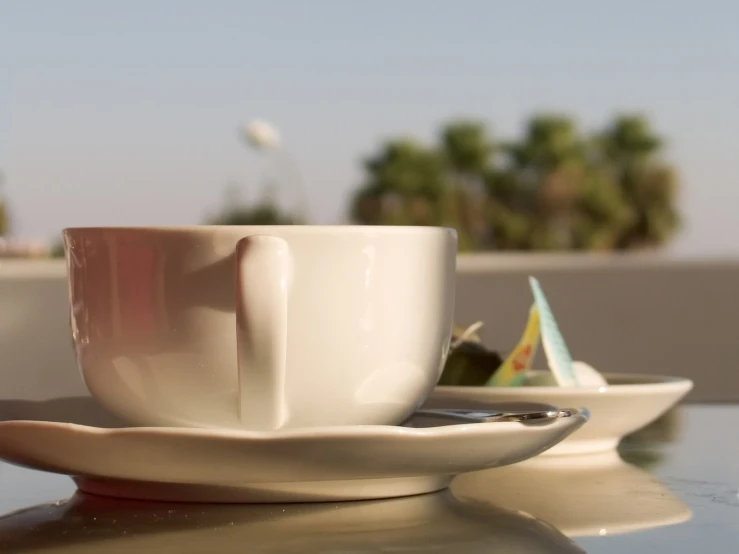 a coffee cup sits on a saucer next to some other cups