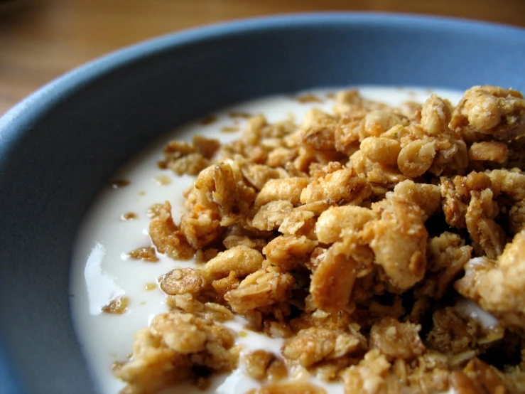 a plate of cereal, with cream and crumbs on top