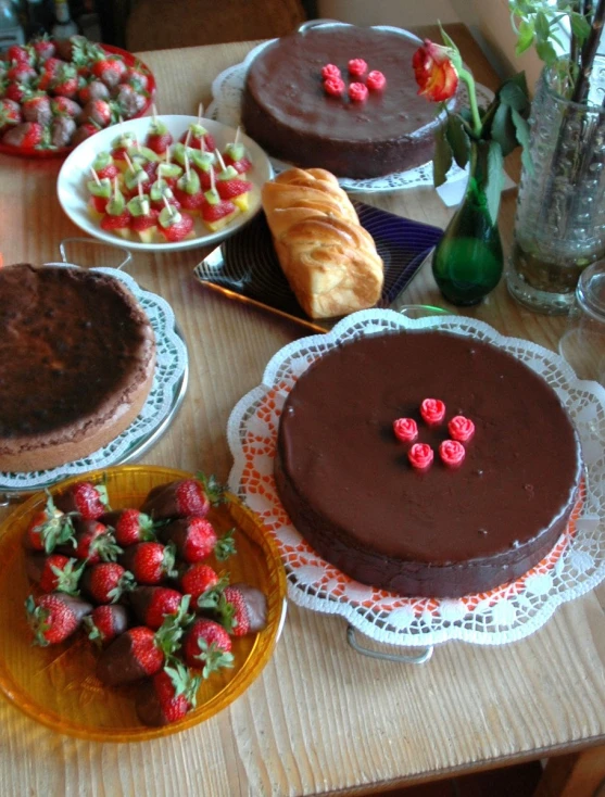 several different chocolate cakes sitting on plates with flowers on them