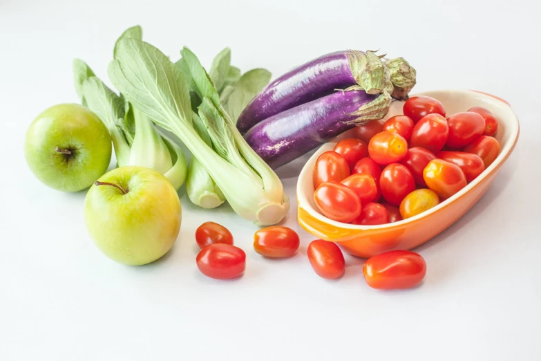 fresh vegetables are in a bowl with fruits and vegetables next to them