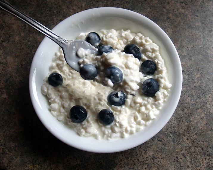 a bowl of oatmeal with blueberries and cream