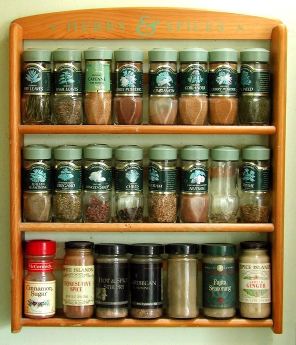 spices hanging on a wooden wall shelf above a door