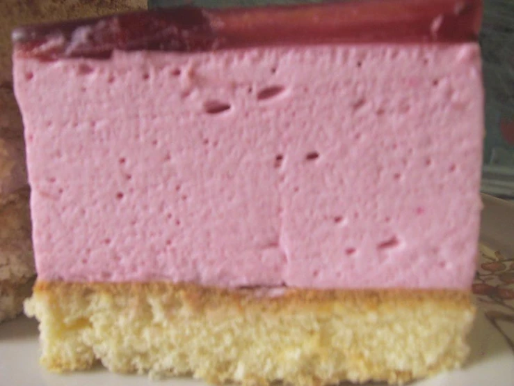 a piece of cake with pink icing sitting on a plate