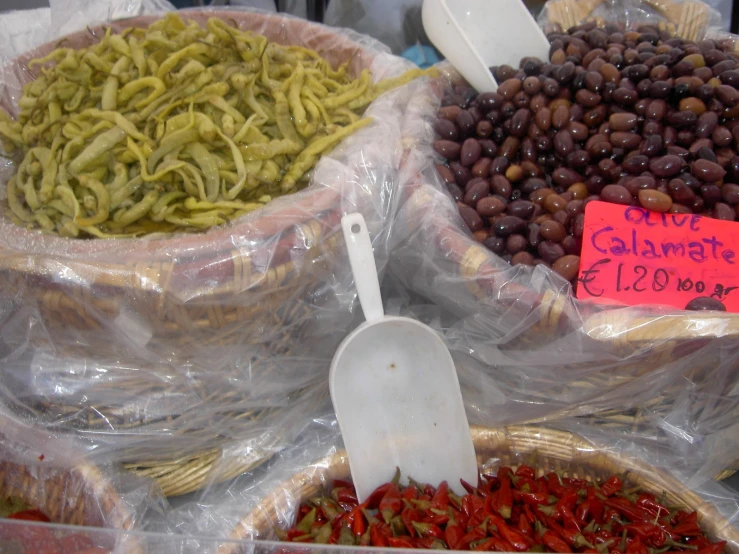 some black olives and other foods are for sale in bags