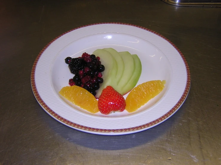 the fruit plate has several slices of kiwi, raspberries, and apple slices on it