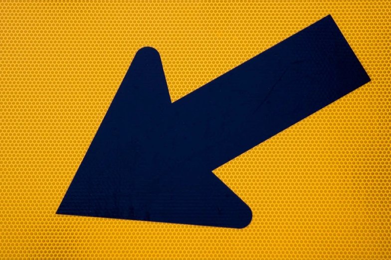 an arrow sign is on yellow and black