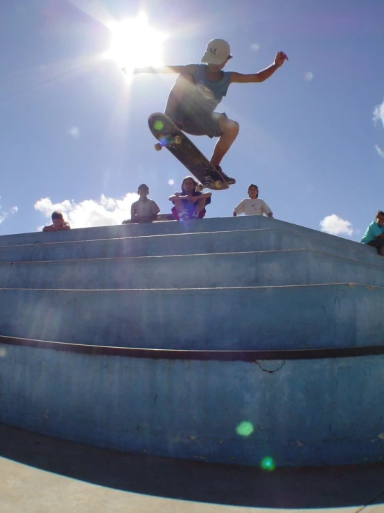 a boy in white shirt jumping on his skateboard