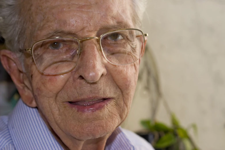 an old man wearing glasses and striped shirt