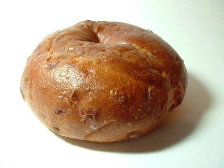 there is an unwrapped bagel that has been bitten
