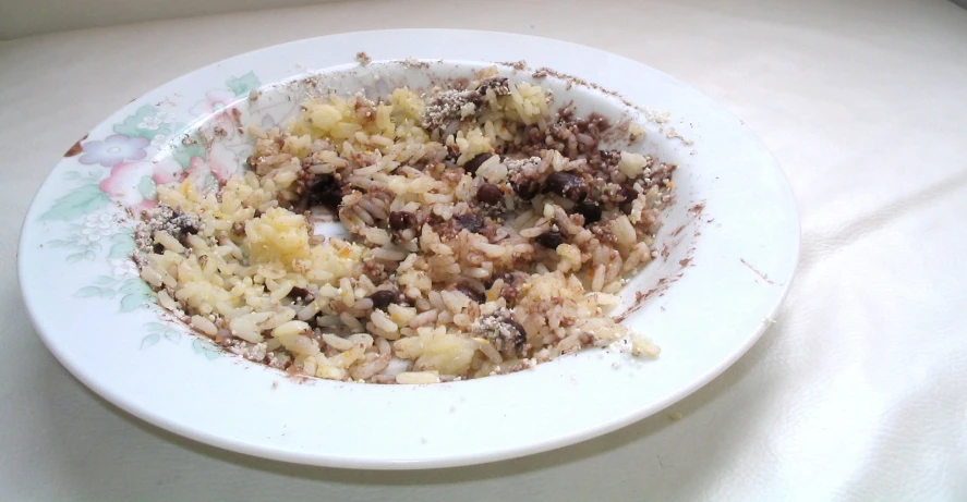 a plate with rice on top of a white surface