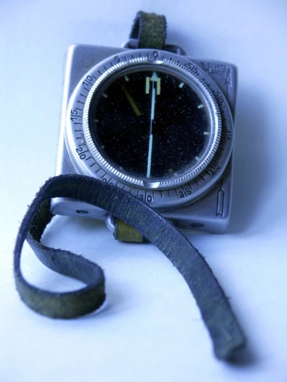 a metal watch sitting on top of a leather strap